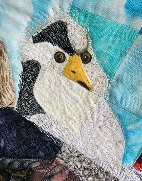 Close-up of a chicken face on a quilt