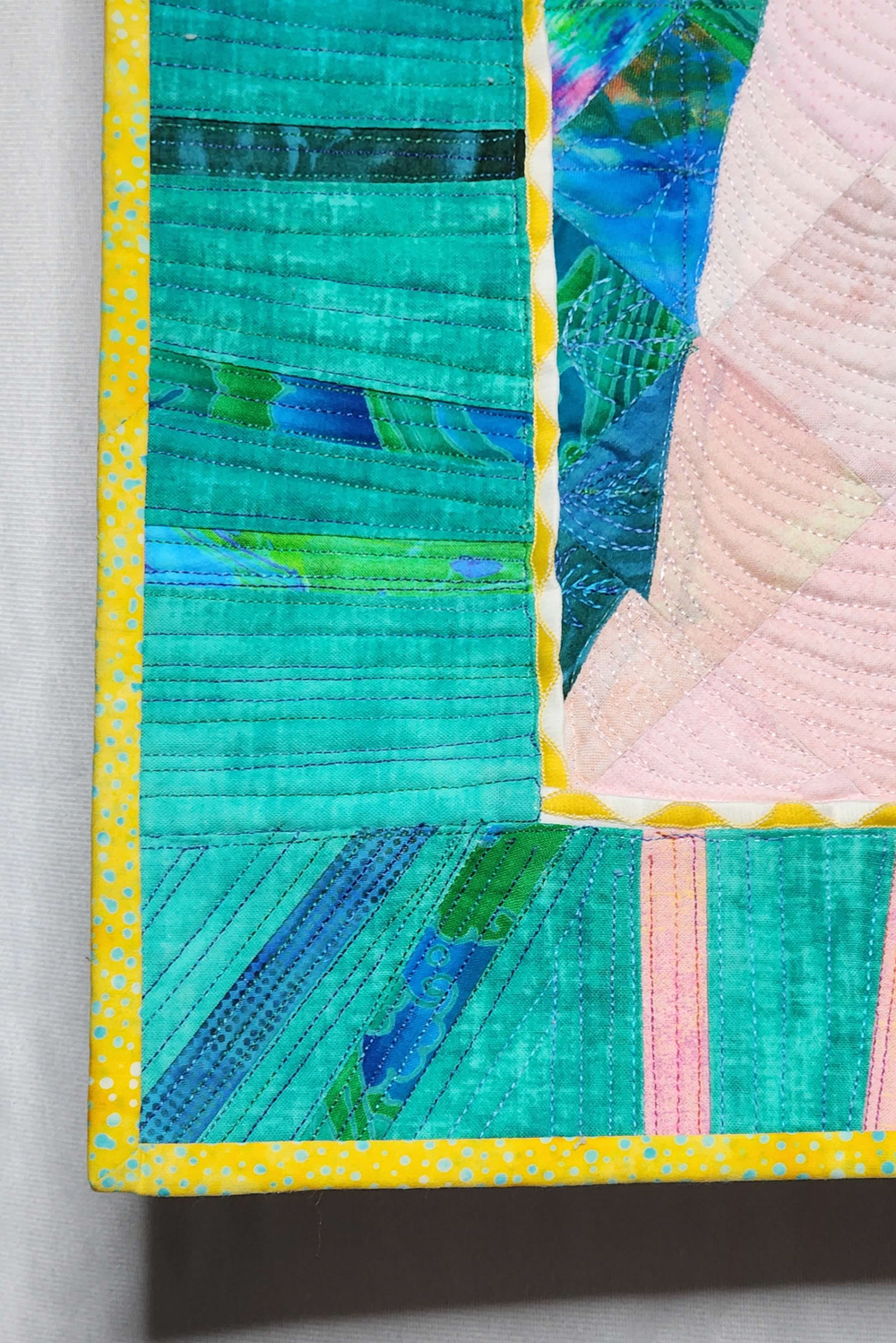 Detail of quilt corner showing green and blue fabric